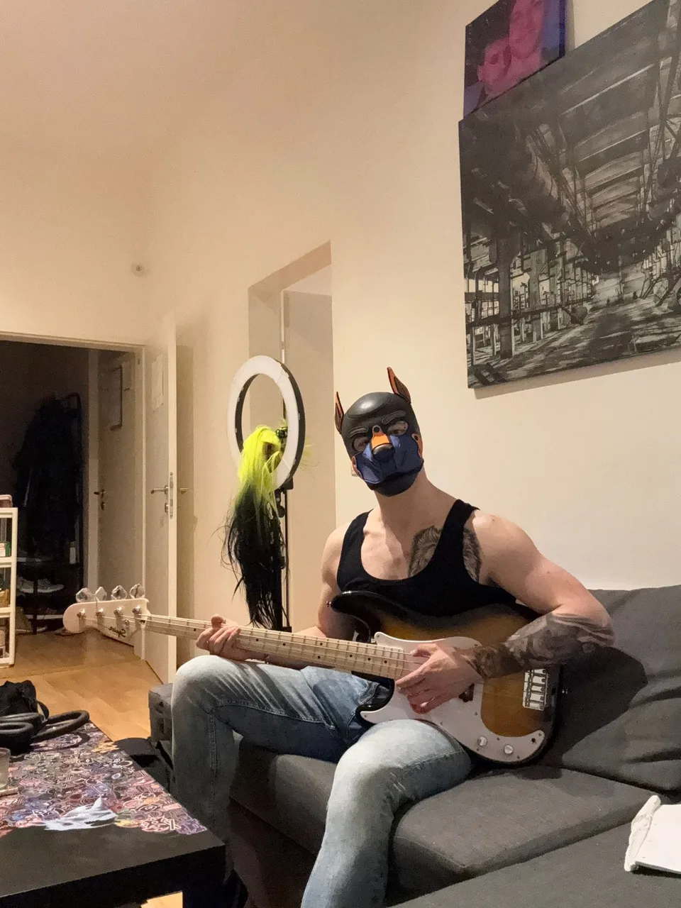 Pup Bacu playing electric bass on the sofa